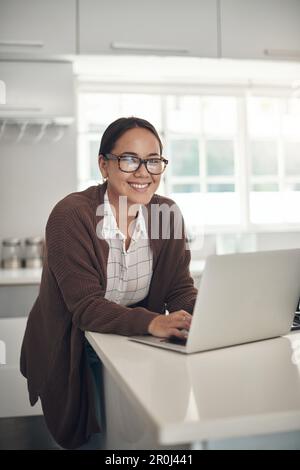 The perks of being a freelancer are many. Portrait of a young woman using a laptop at home. Stock Photo
