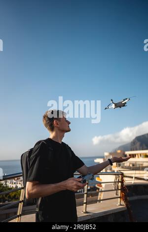 young photographer launching quadcopter drone from hand with remote controller Stock Photo