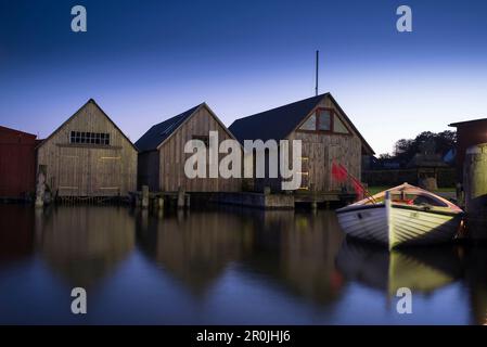 Fishing boat in front of boathouses in the harbour in Ahrenshoop am Bodden in the blue hour, Ahrenshoop, Mecklenburg Vorpommern, Germany Stock Photo