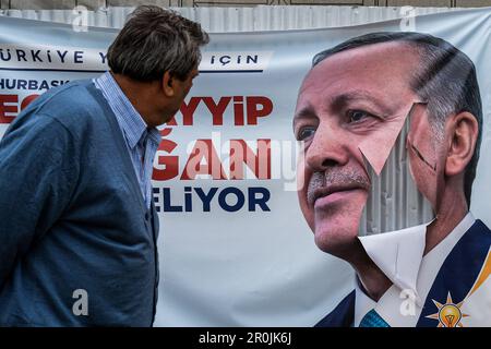Izmir, Turkey. 05th May, 2023. A man looks at a torn banner of Recep Tayyip Erdogan. 5 days left until the 2023 elections. The election campaign continues for the two major candidates, Recep Tayyip Erdogan and Kemal Kilicdaroglu. People go for elections with great excitement under the shadow of election posters. Credit: SOPA Images Limited/Alamy Live News Stock Photo