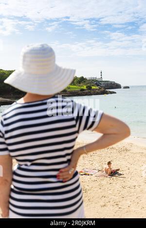 Tourist on the beach looking towards the lighthouse, Mediterranean Sea, Portocolom, Majorca, Balearic Islands, Spain, Europe Stock Photo