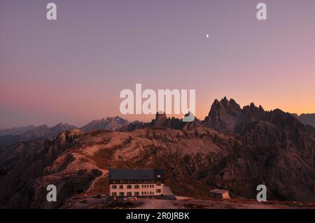 hut Rifugio Auronzo and peaks of Cadini di Misurina after sunset with moon, Val Pusteria Valley, Sesto, Dolomites, South Tyrol, Veneto, Alto Adige, Th Stock Photo