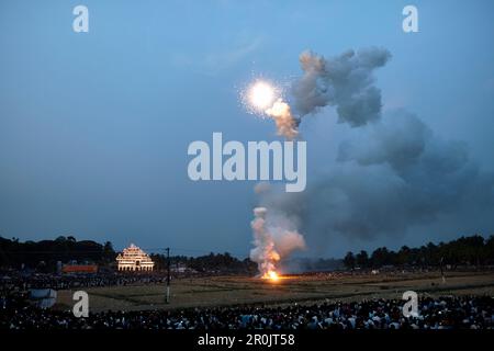 Deafening fireworks, harvested rice fields, hundreds of thousands of visitors around it, illuminated timber scaffolding Aana Pandal in the back, Nemma Stock Photo