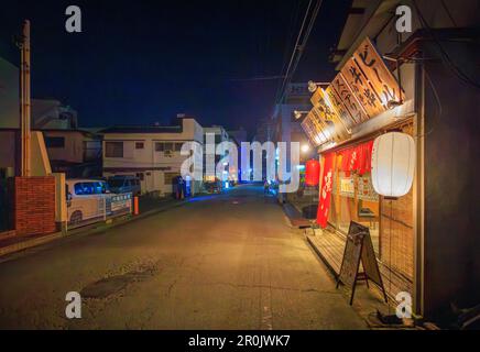 Higashikakogawa, Japan - May 5, 2023: Signs over brightly lit Japanese restaurant on quiet street at night Stock Photo