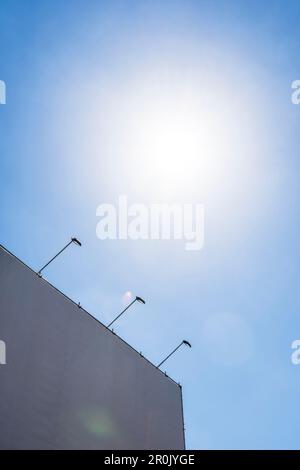 An unused surface, normaly for advertisement, with spotlights during the day against light and blue sky, Hamburg, Germany Stock Photo