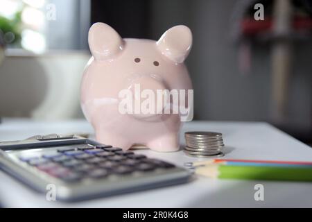 An image of a finance and business concept centered around a piggy bank on an office table Stock Photo