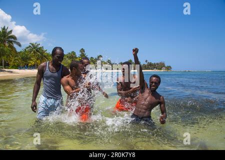 Splashing guides of Half Moon Resort horseback ride excursion in Caribbean Sea Rose Hall, near Montego Bay, Saint James, Jamaica Stock Photo