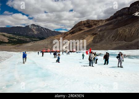Tourists and Columbia Icefield explorer vehicles on melting Athabasca Glacier, Jasper national park, Alberta, Canada. Stock Photo