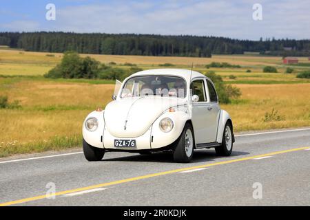 Off-white Volkswagen Beetle, officially Volkswagen Type 1, driving along country road on Maisemaruise 2019 car cruise. Vaulammi, Finland. August 3, 20 Stock Photo
