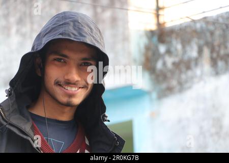 A Young Beautiful Boy Smiling in Portrait. Wearing hoodie, outside in street looking in camera. Stock Photo