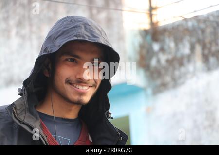 A Young Beautiful Boy Smiling in Portrait. Wearing hoodie, outside in street looking in camera. Stock Photo