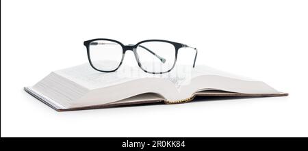 The reading glasses on opened book isolated on the white background. Stock Photo