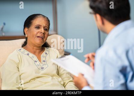 Indian senior woman explaining problems to psychologist during counselling at home - concept of home appointment, troube assessment and mental illness Stock Photo
