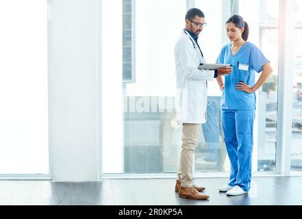 Collaborating with your care in mind. two young doctors using a digital tablet in a modern hospital. Stock Photo