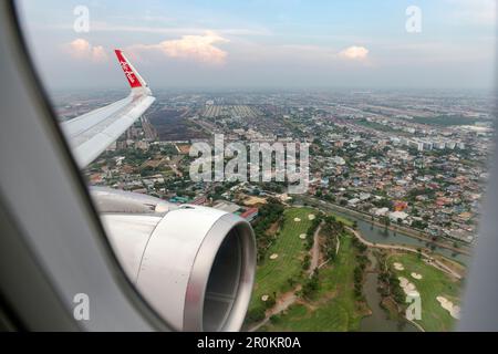 Bangkok Thailand - March 30, 2019:The image depicts the view outside the window showing the wing and engine of an AirAsia low-cost airline aircraft du Stock Photo