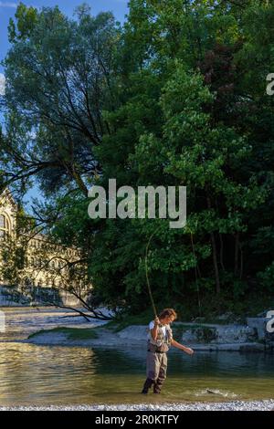 A Fisherman just catched a Trout in the river Isar in the Middle of Town,  in the back you can see the Müllersches Volksbad, Munich, Upper Bavaria,  Ger Stock Photo - Alamy