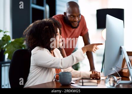 This is what we need to focus on. two young designers looking at something on a computer screen. Stock Photo