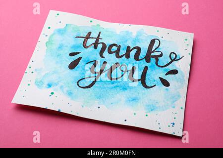 Card with phrase Thank You on pink background Stock Photo