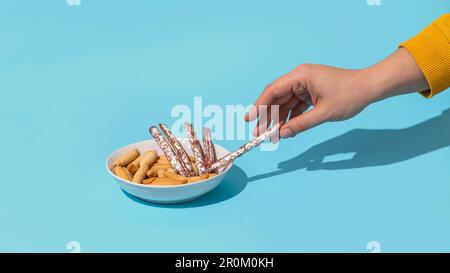 Womans hand take mini fuet from bowl Stock Photo
