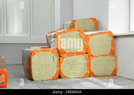 Stacked packages of thermal insulation material in room Stock Photo