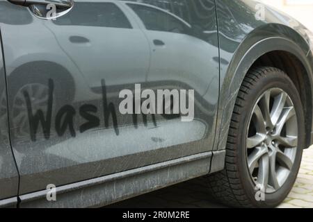 Phrase Wash Me written on dirty car, closeup Stock Photo