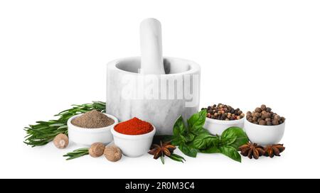 Mortar with pestle and different spices on white background Stock Photo