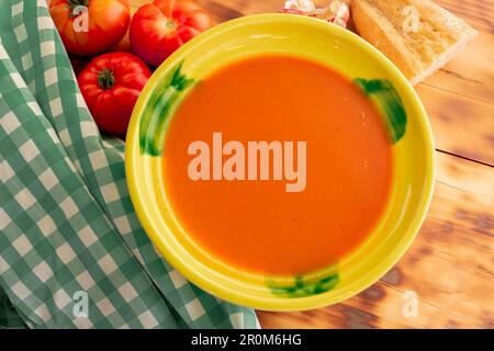 gazpacho, typical food from the South of Spain,tomato soup served in a traditional yellow ceramic bowl.Concept of Spanish gastronomy Stock Photo
