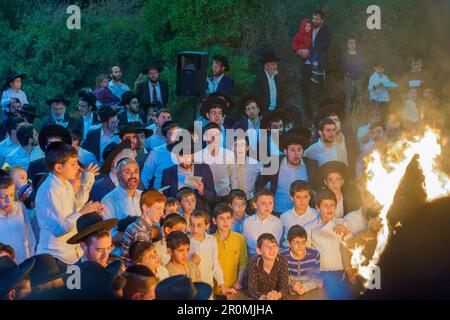 Haifa, Israel - May 08, 2023: Ultra-Orthodox Jews gather around a fire to celebrate the Annual Holiday of Lag-BaOmer, in Haifa, Israel Stock Photo