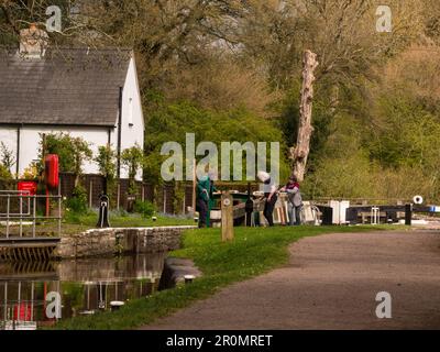 Man and two women operating Brynich lock to raise water for narrowboat to proceed towards Brecon on Monmouthshire and Brecon canal Powys Mid Wales UK Stock Photo