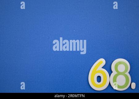 The number 68, placed on a blue background, photographed from above ...