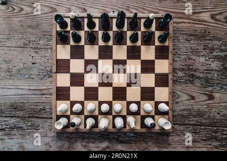 From above view of chessboard with chess pieces on wood background Stock Photo