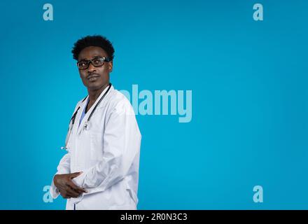 Confident handsome african american doctor wearing eyeglasses, blue background Stock Photo