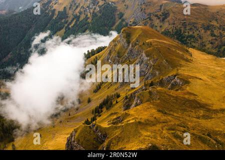 The slopes of the famous Giau Pass are adorned by a lofty mountain range, enveloped by clouds Stock Photo