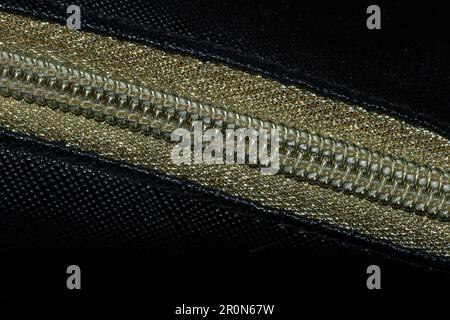 Golden zipped on a black background , Golden plastic zipper Stock Photo
