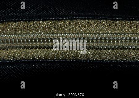 Golden zipped on a black background , Golden plastic zipper Stock Photo