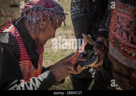 Kyrgyz hits horseshoe on horseback, Afghanistan, Asia Stock Photo