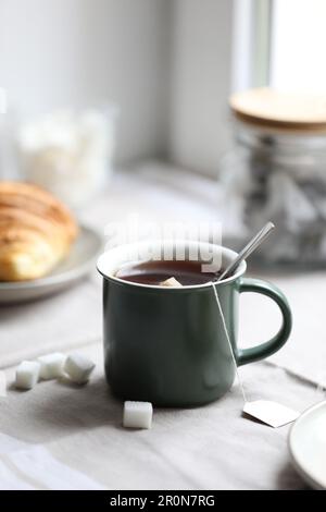 Cup of freshly brewed tea and sugar cubes on table Stock Photo