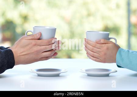 Hands of couple with coffee cups Stock Photo