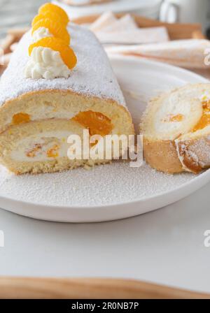 Swiss roll cake with mandarin orange filling on a platter Stock Photo