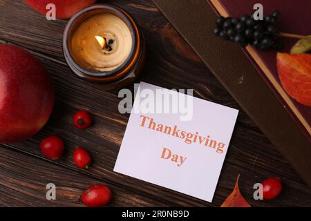 Thanksgiving Day. Flat lay composition with paper card and autumn leaves on wooden table Stock Photo