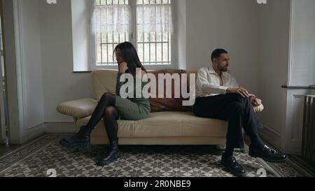 Alienated couple on the brink of separation. Young man and woman giving each other the silent treatment during relationship crisis Stock Photo