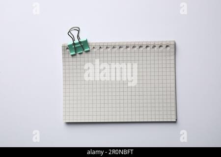 Checkered sheets of paper with binder clip on white background, top view Stock Photo