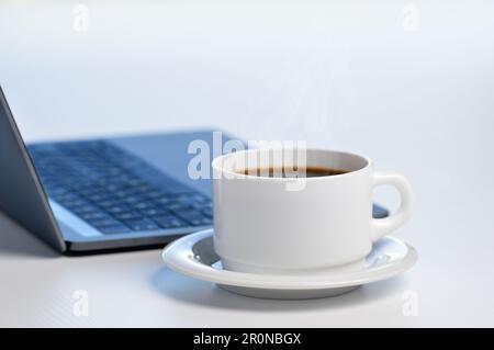 Laptop on a table workplace with a cup of coffee in a home interior or office Stock Photo