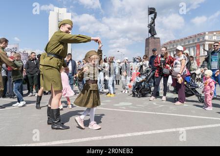 Vladivostok, Russia. 9th May, 2023. A woman and a girl in Soviet military uniforms during World War II dance in a celebration marking the 78th anniversary of the Soviet victory in the Great Patriotic War, Russia's term for World War II, in Vladivostok, Russia, May 9, 2023. Credit: Guo Feizhou/Xinhua/Alamy Live News Stock Photo