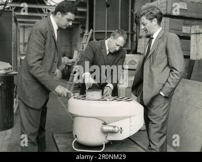 A team of engineers examining a scale model of deep-diving research submarine SURV, UK 1966 Stock Photo