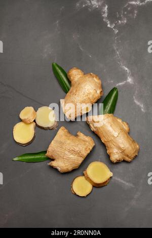 Pieces of ginger root on a black marble kitchen counter in top view Stock Photo