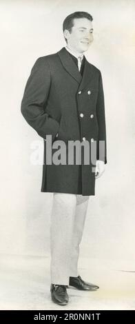 Fashion model man wearing a sport car coat in black cotelè wool by Italian designer Brioni, 1966 Stock Photo