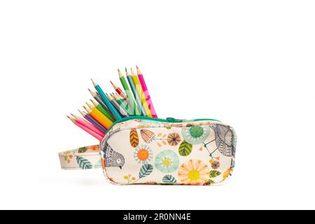 Color pencils in a colored plant print hand bag on a white background with copy space Stock Photo