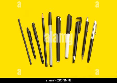 Markers, pens and pencils on a yellow background with copy space Stock Photo