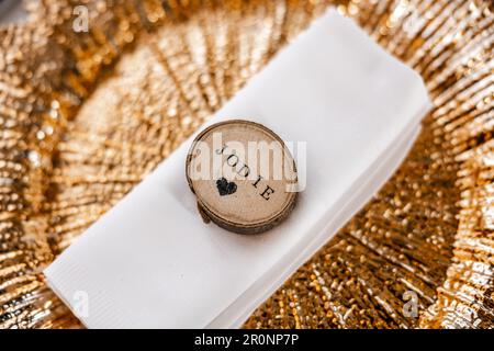 The name Jodie - Stunning gold plated dinner plate with wooden name tag and love heart chopped wood log Stock Photo